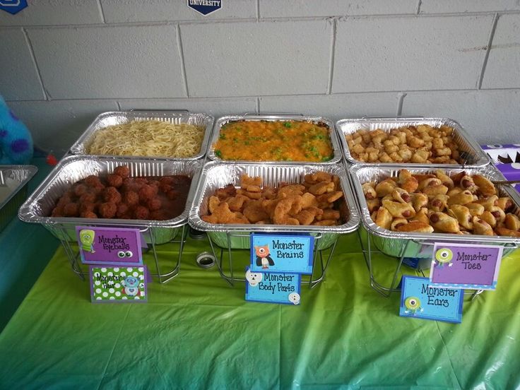 there are many trays of food on the table with name tags in front of them