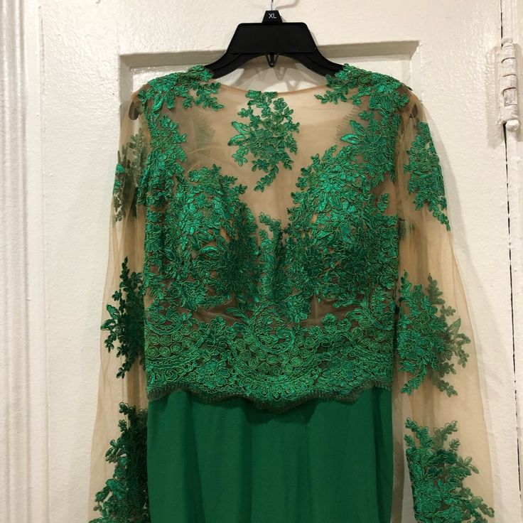 a dress hanging on a hanger in front of a white door with green trim