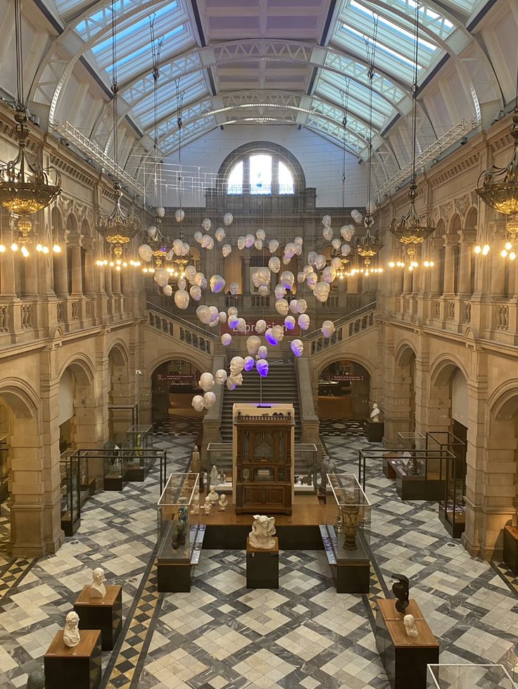 the inside of a large building with lots of balloons hanging from it's ceiling