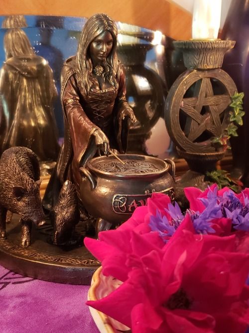 a table topped with vases and figurines on top of a purple cloth