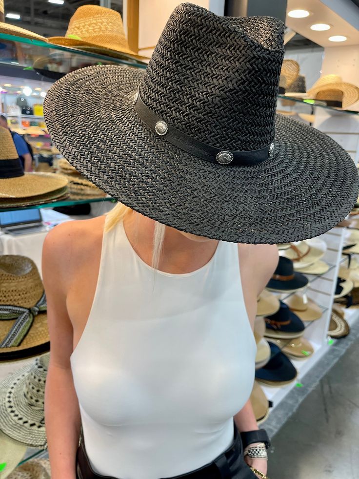 Our Bandera straw hat fits in perfectly with your spring and summer wardrobe, whether at the pool, beach or a concert! On trend w/ a western vibe, classic, chic - everything you've ever wanted in a hat. Featuring a molded crown with a pinched 10cm brim and hand woven straw, it's embellished with a faux leather and silver antique button trim. Finished off with a tassel at the back. -Rancher style hat with a chill & casual vibe-Brim is flexible but holds its shape-Coordinating faux leather band-Pi Adjustable Straw Boater Hat For Rodeo, Black Panama Hat For Summer Beach Season, Black Panama Hat For Beach Season, Trendy Straw Hat For Kentucky Derby Beach, Black Summer Panama Hat For Beach Season, Trendy Straw Hat For Beach And Kentucky Derby, Straw Boater Hat With Curved Brim For Rodeo, Casual Straw Boater Hat For Country Events, Black Flat Brim Sun Hat For Summer