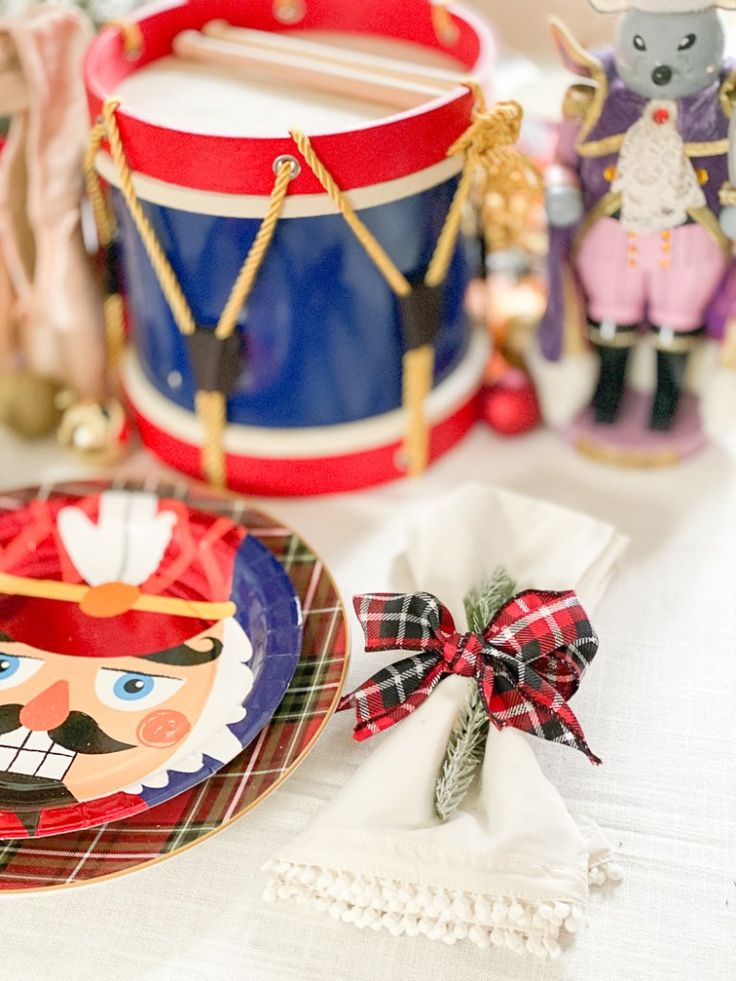 a table topped with plates and figurines on top of a white table cloth