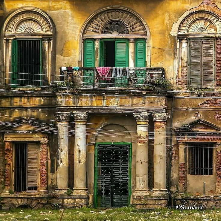 an old building with green shutters and balconies