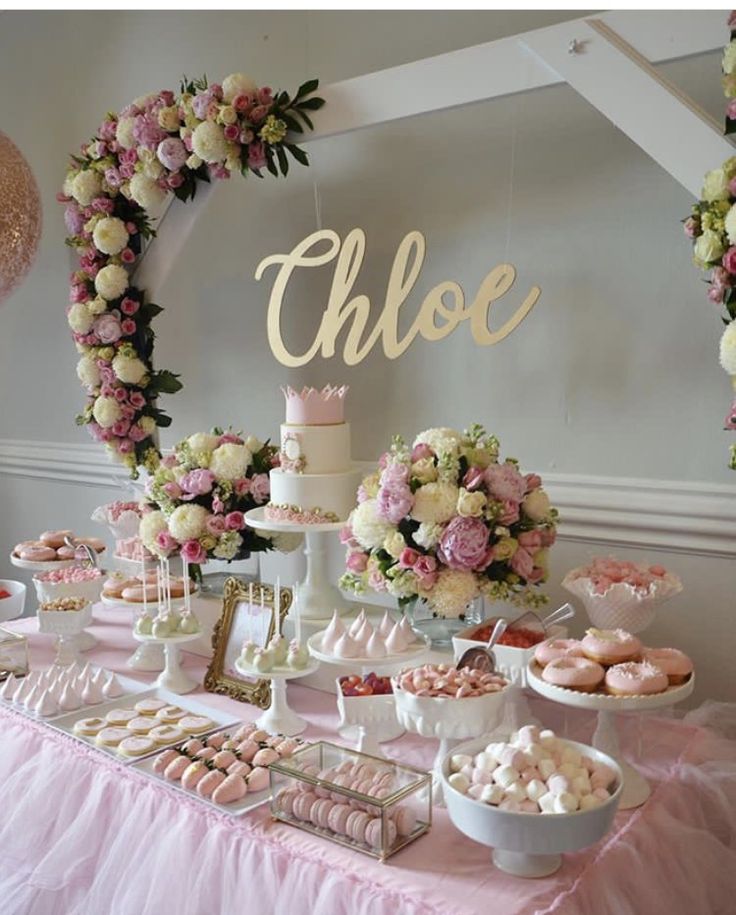 a table topped with lots of desserts next to a cake and cupcake display