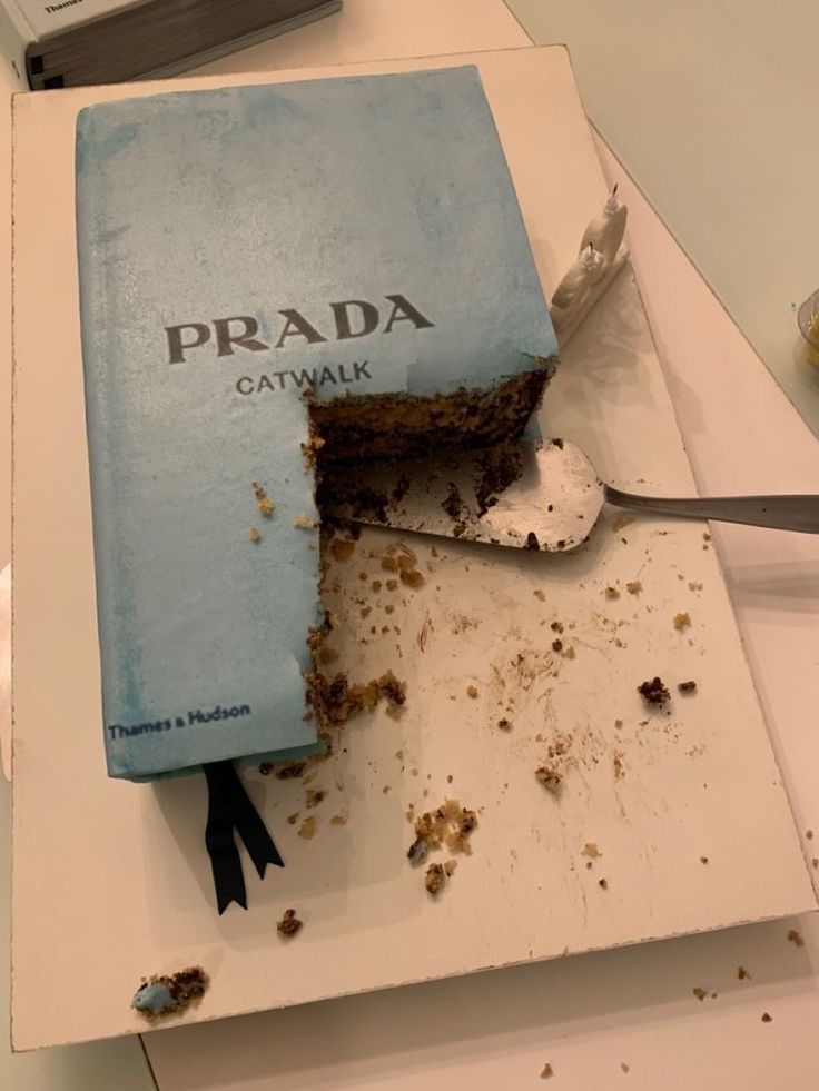 a piece of cake that is on top of a book with the word prada cut in half