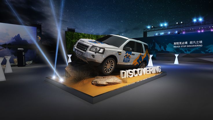 an suv is on display in front of a large screen with the words discovery written across it