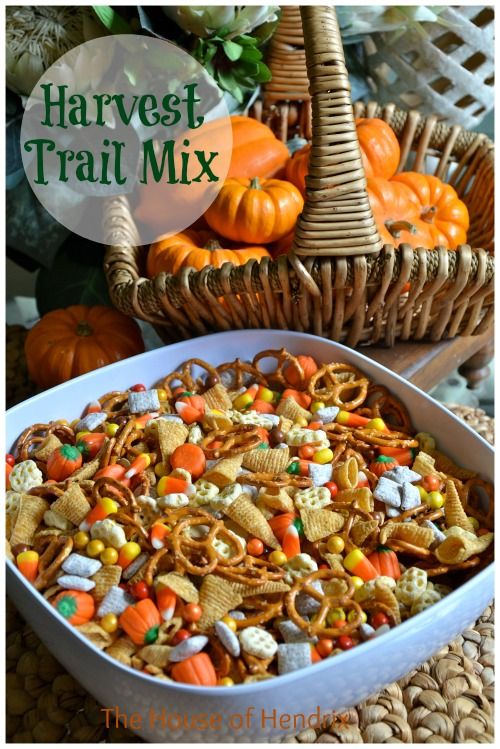 a white bowl filled with halloween treats next to a wicker basket full of pumpkins