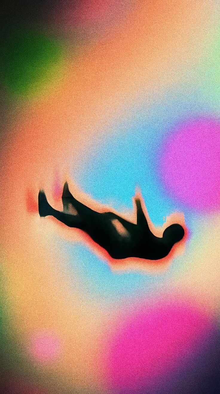 a person floating in the air with their feet up and legs down, on a multicolored background