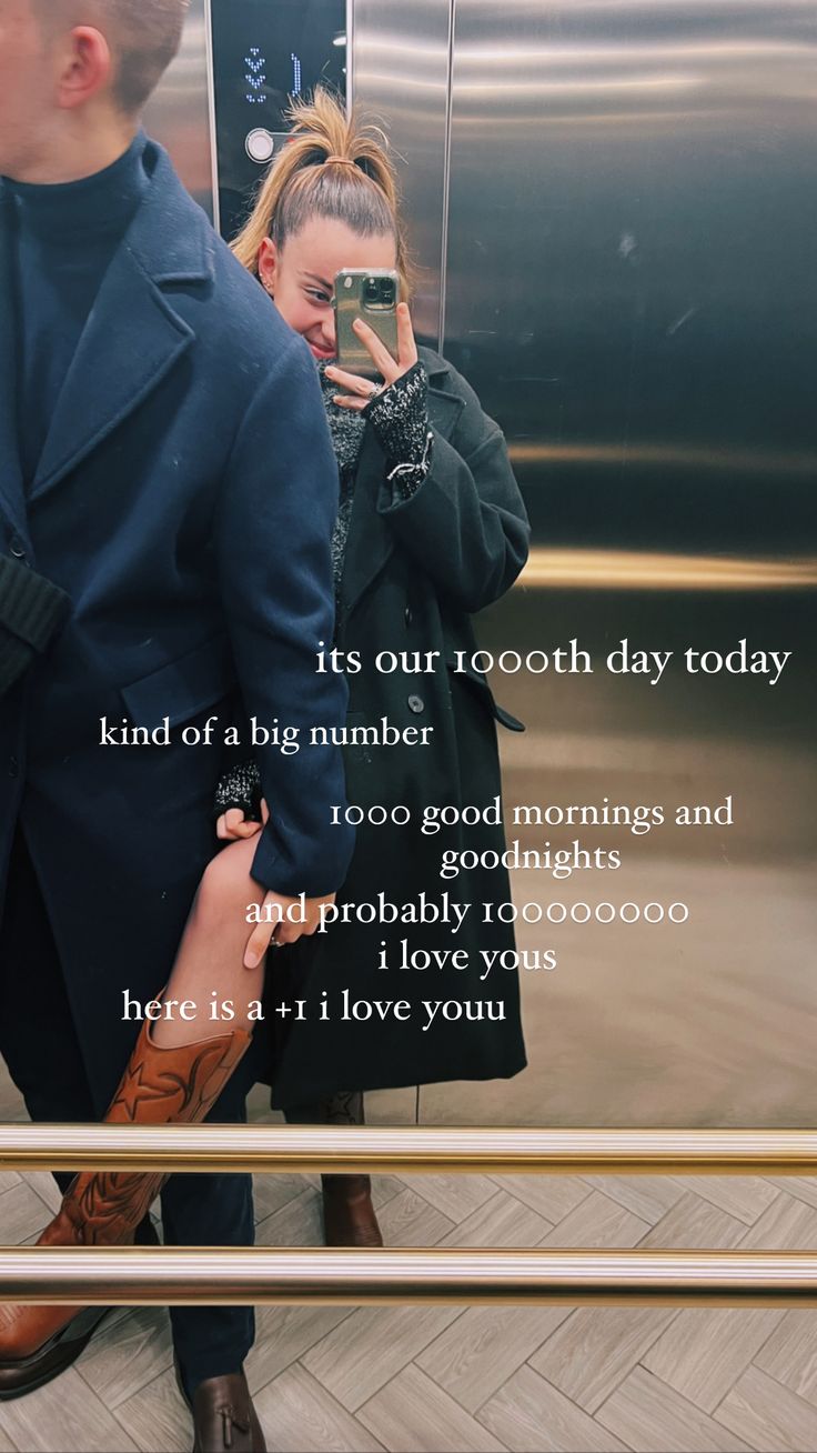 a man and woman standing next to each other in front of a metal elevator door