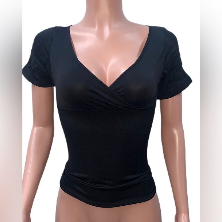 Get Ready To Elevate Your Wardrobe With This Black Fitted Stretchy Tank Top. The Low-Cut V-Neckline And Faux Wrap Design Creates A Flattering Cleavage While The Slim Fit Showcases Your Curves. The Seamless Construction And Stretchy Material Add Comfort And Flexibility To Your Everyday Wear, Making It A Perfect Addition To Your Casual Chic Or Party Clubbing Outfits. This One Size Tank Top Is Made Of Nylon/Spandex Material And Features Short Sleeves. The Versatile Design And Black Color Make It Ea Stretch V-neck Crop Top For Night Out, Fitted Low-cut Top With Built-in Bra, Black V-neck Crop Top With Built-in Bra, Fitted V-neck Top With Medium Bust Support, Black Stretch V-neck Crop Top, High Stretch V-neck Tops For Night Out, Trendy Fitted Tops With Medium Bust Support, Elegant V-neck Crop Top With Built-in Bra, V-neck Stretch Crop Top With Built-in Bra