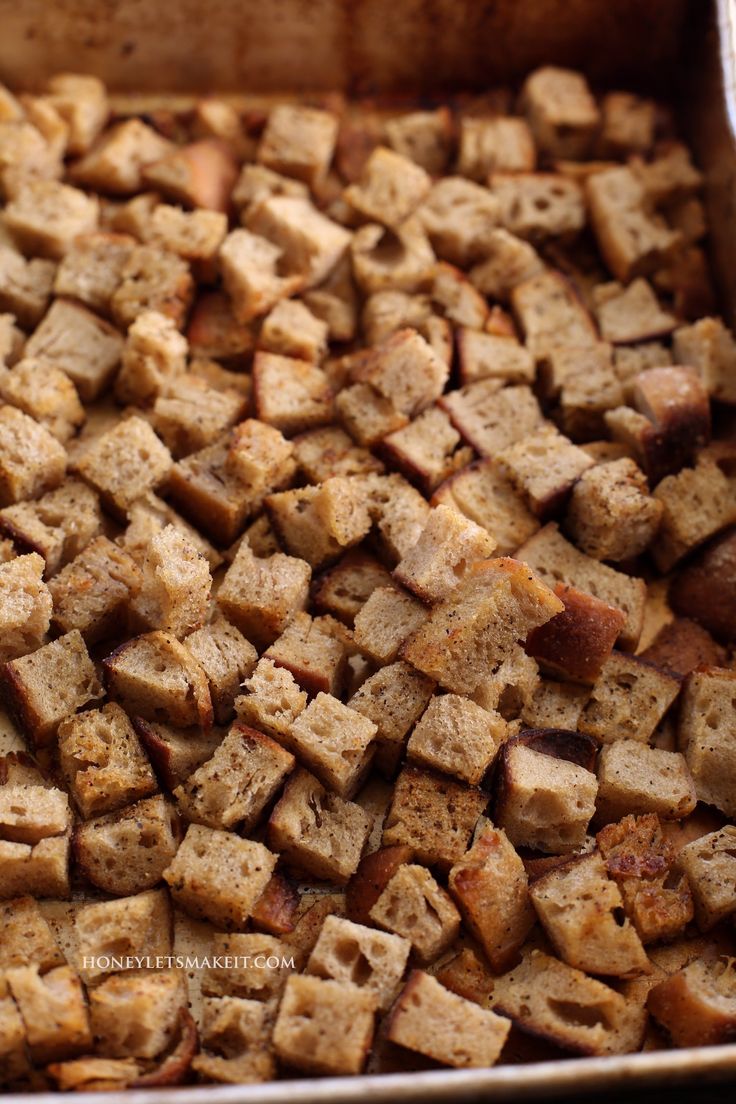 a pan filled with bread cubes sitting on top of a table