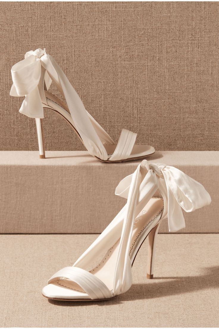 a pair of white shoes with bows on them