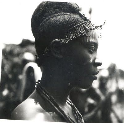 an old black and white photo of a woman with braids on her head, looking off to the side