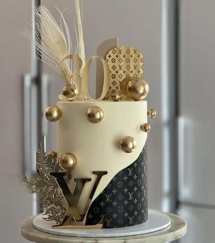 a white and black cake with gold decorations