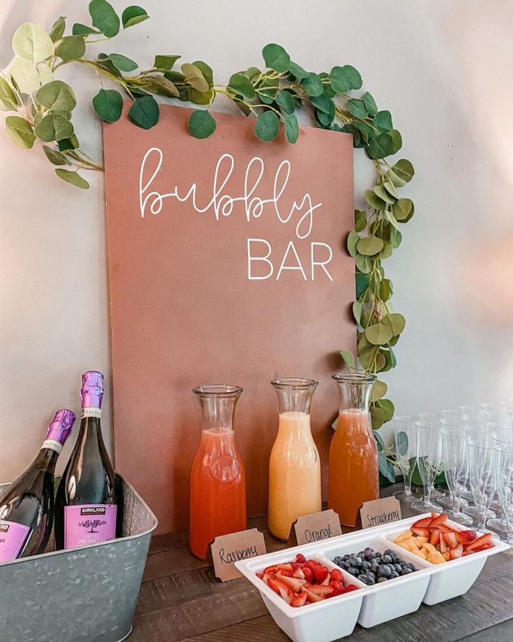 there is a sign that says bubbly bar next to some fruit and drinks on the table