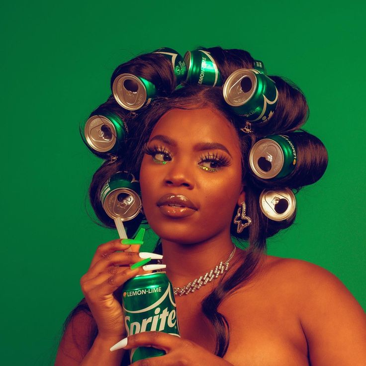 a woman with curlers on her head holding a can of drink