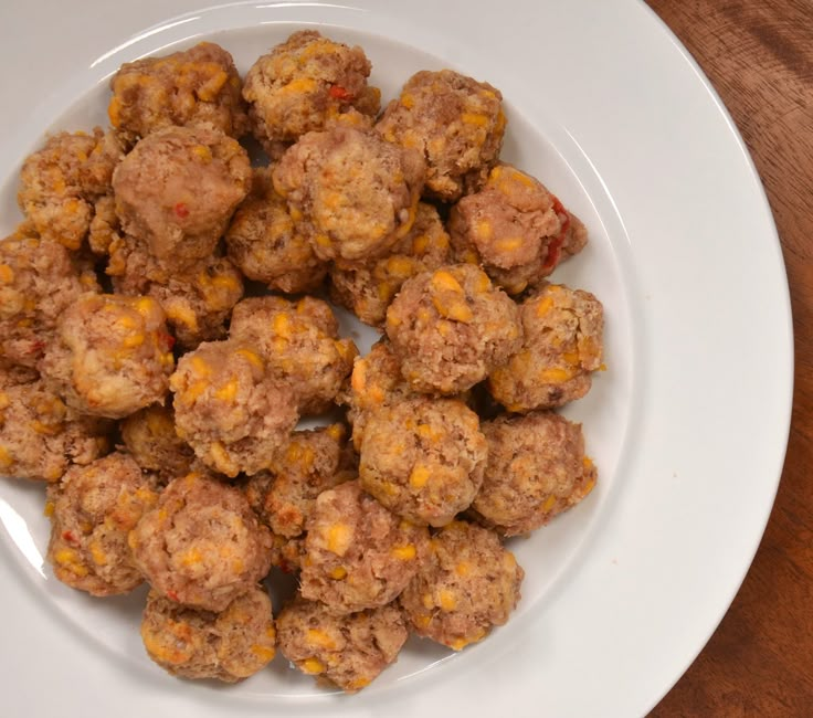 a white plate topped with meatballs on top of a wooden table