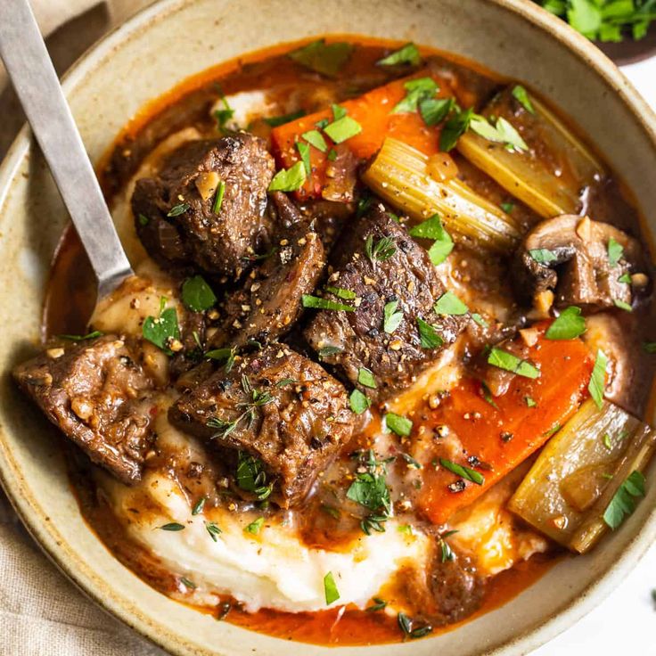 a bowl filled with meat and vegetables on top of a table