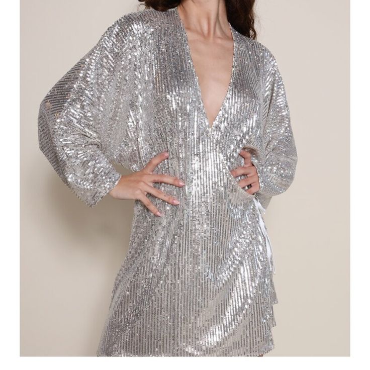 Slinky Sequin Wrap Dress With A Silver/Gold Hue Wear It Tied Closed Or Open Like A Kimono! Model Wearing Size Small Shiny V-neck Party Dresses, Metallic V-neck Mini Dress For Party Season, Shiny V-neck Dress For Party Season, Silver V-neck Sequin Party Dress, Metallic Sequin Cocktail Dress, Metallic Disco Evening Dress, Glamorous Shiny V-neck Dress, Metallic Shine Dresses For Party Season, Metallic Disco Dress For The Holidays