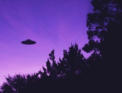 a purple sky with an object flying in the air and trees around it at dusk