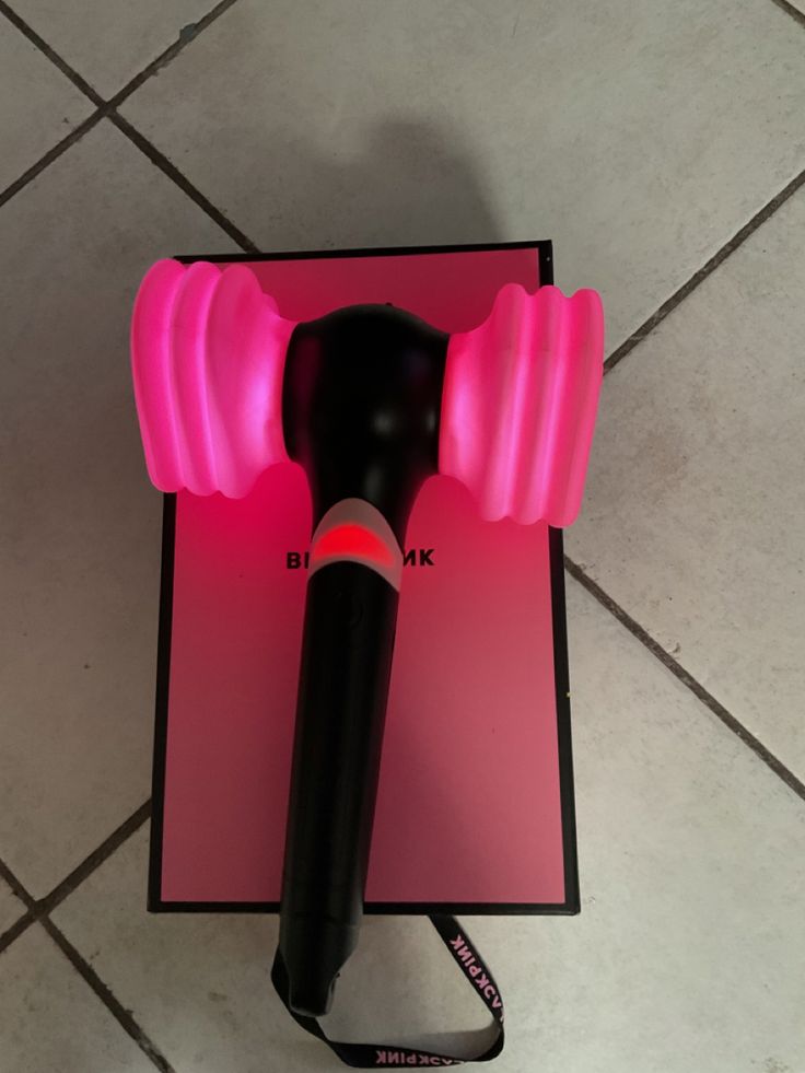 a pink and black hair dryer sitting on top of a table