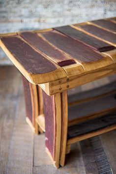 a wooden table sitting on top of a hard wood floor next to a brick wall