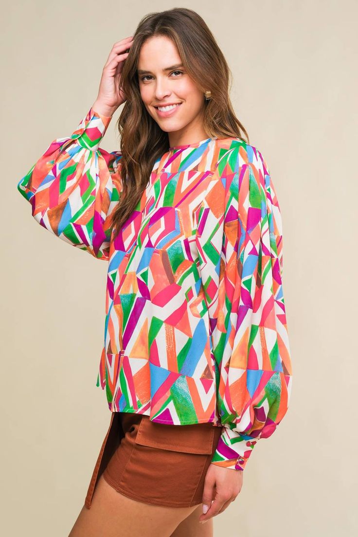 A printed woven top featuring round neckline, wide long sleeve with cuff and back neck button closure Details: Self : 100% Polyester Size & Fit - Model is 5`8" And Wearing Size Small- Measurements Taken From Size Small- Approx. Length: 24" Chic Oversized Multicolor Blouse, Oversized Printed Long Sleeve Blouse, Trendy Oversized Multicolor Blouse, Oversized Long Sleeve Printed Blouse, Colorful Long Sleeve Blouse For Spring, Trendy Long Sleeve Printed Blouse, Colorful Pattern Long Sleeve Blouse For Spring, Fall Multicolor Lantern Sleeve Blouse, Oversized All Over Print Tops For Spring