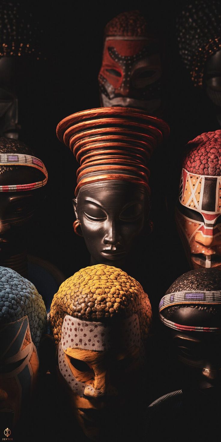 an assortment of african headdresses are displayed in the dark with black background