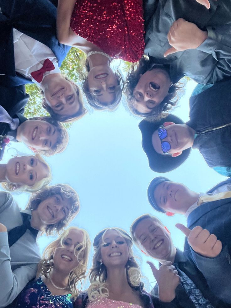 a group of people standing in a circle with their hands together and smiling at the camera