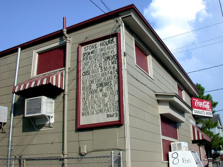 an old building with signs on the side of it and a sign that says store hours