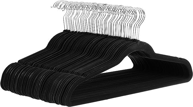 three pairs of black and white clothes hangers with clips on each side, one in the