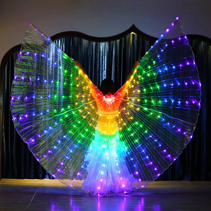 a colorful light up bird with wings on the dance floor in front of a curtain