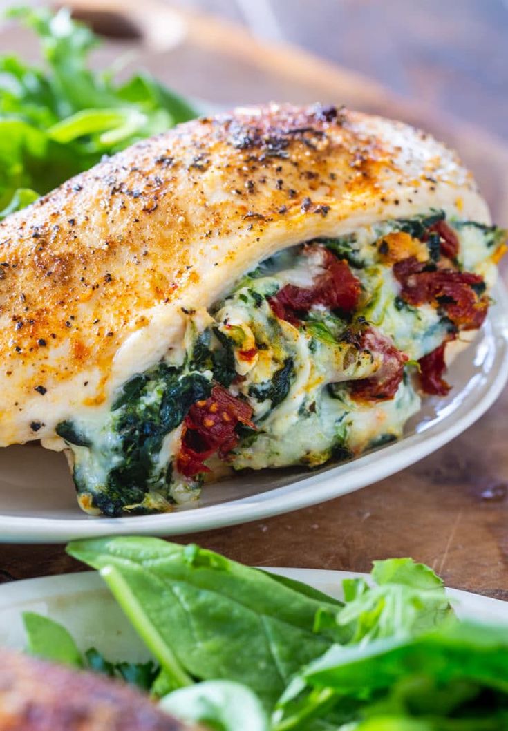 a close up of a plate of food with chicken and spinach on the side