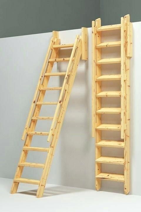 two wooden ladders are next to each other in front of a white wall and gray wall