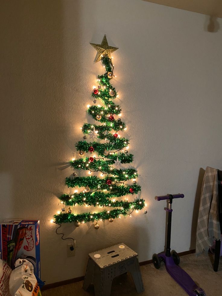 a christmas tree with lights on it in a living room next to a skateboard