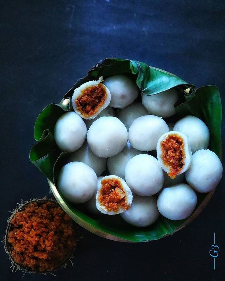 a bowl filled with white eggs next to a small pot full of brown stuff on top of a table