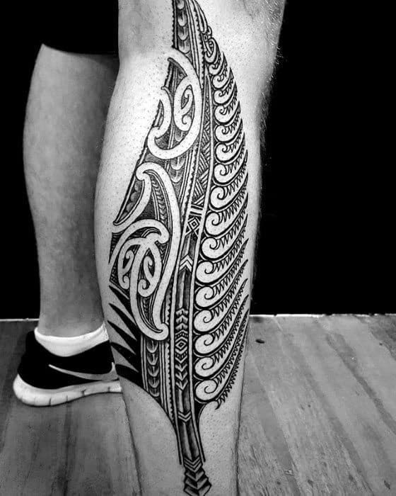 black and white photograph of a man's leg with a feather tattoo on it