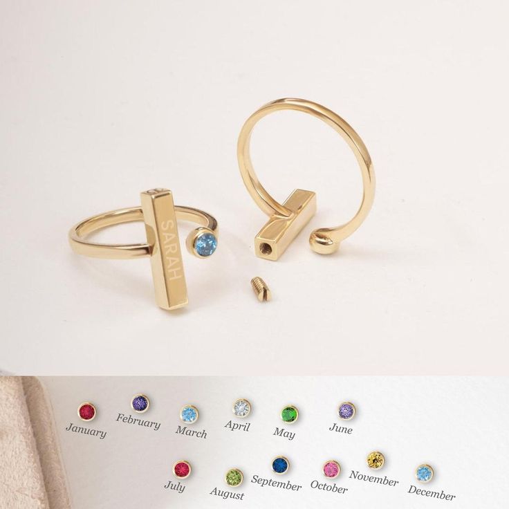 two rings with different colored stones are shown next to an open ring that has the word love written on it