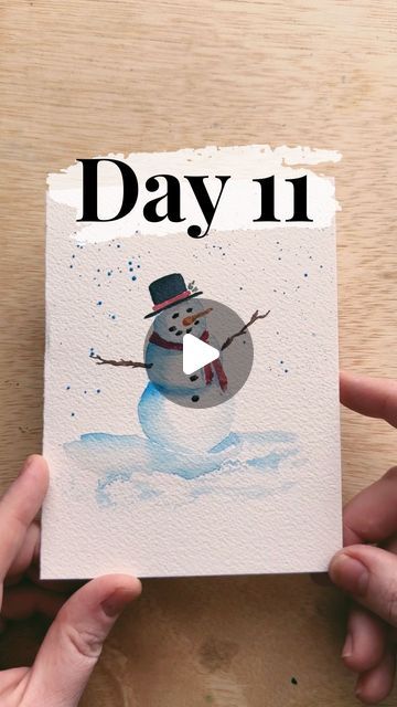 someone holding up a card with a snowman on it and the words day 11