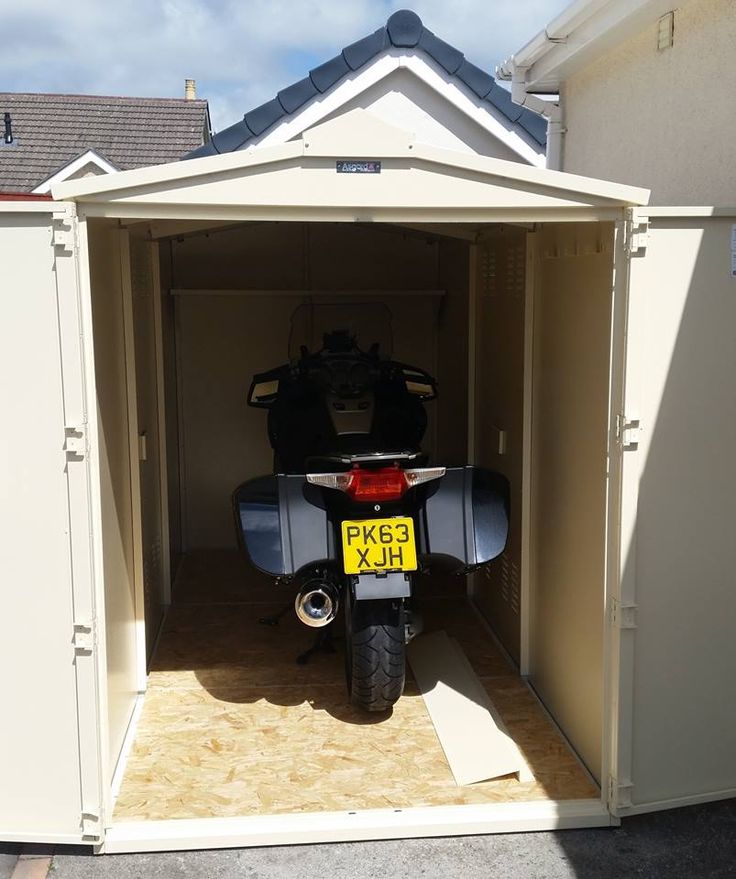 a motorcycle is parked in a storage shed