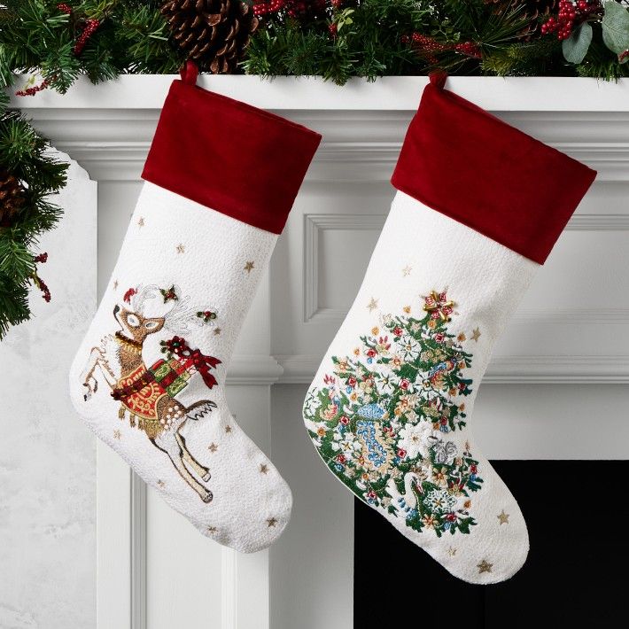 two christmas stockings hanging from a mantel