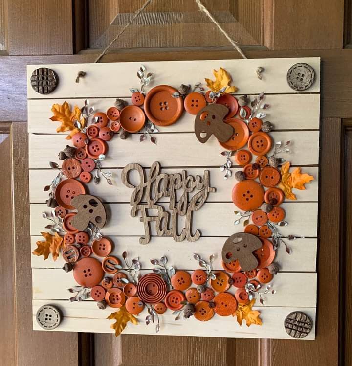 a sign that says happy fall with buttons and leaves hanging from the side of it