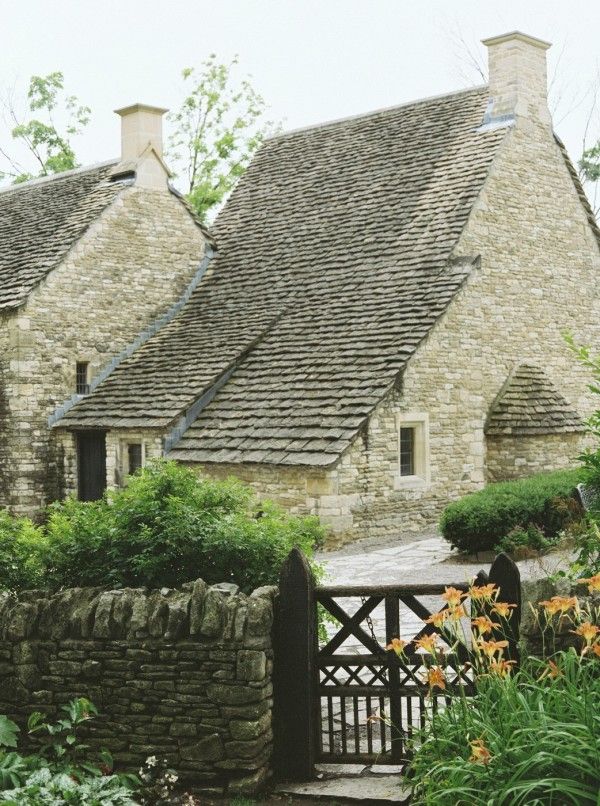 a stone house with a gate in front of it