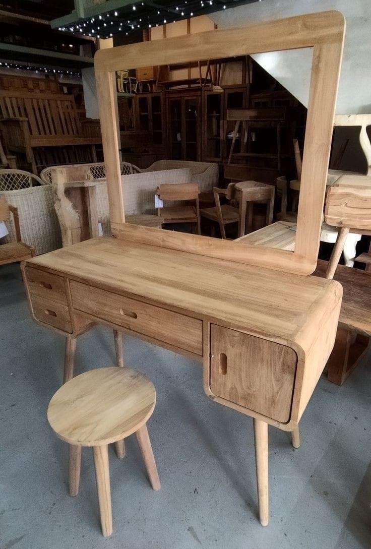 a wooden desk with a mirror and stool