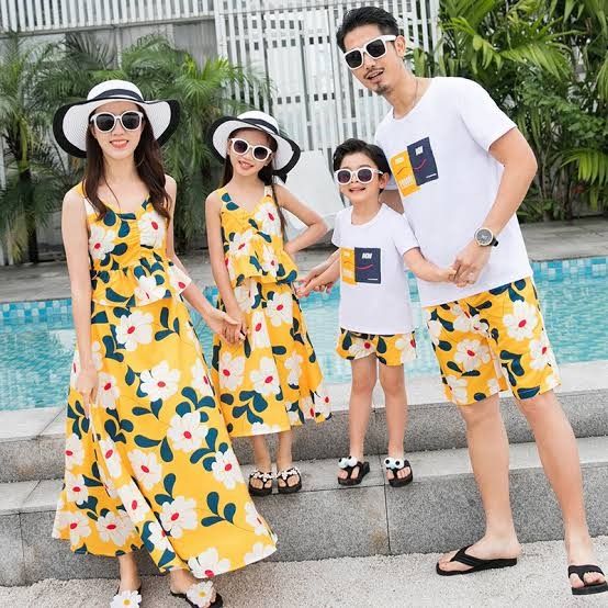 a man and two women standing next to each other in front of a swimming pool