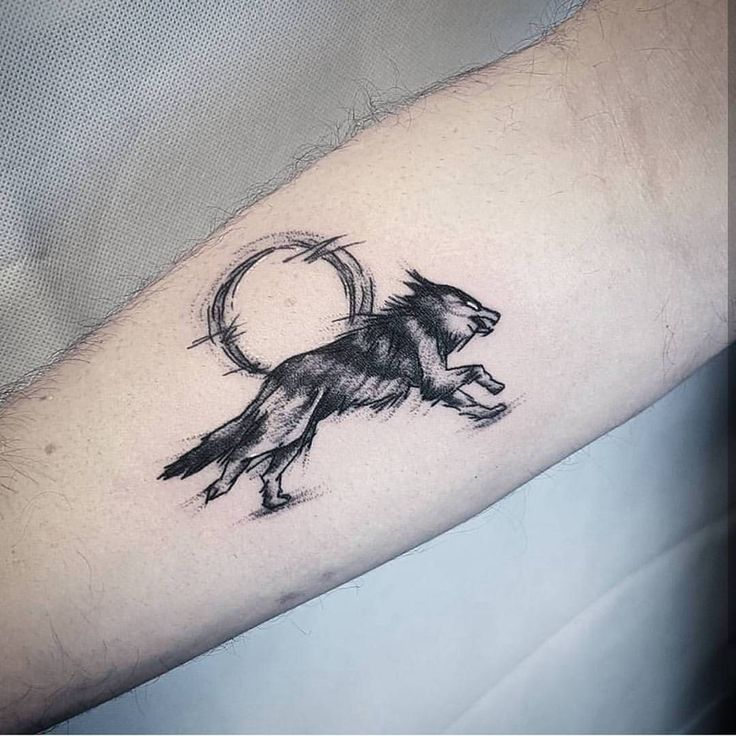 a man's arm with a small tattoo of a lion and a circle on it