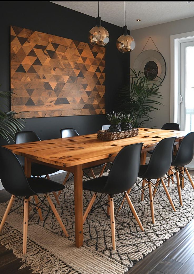 a dining room table with black chairs and a large wooden art piece on the wall