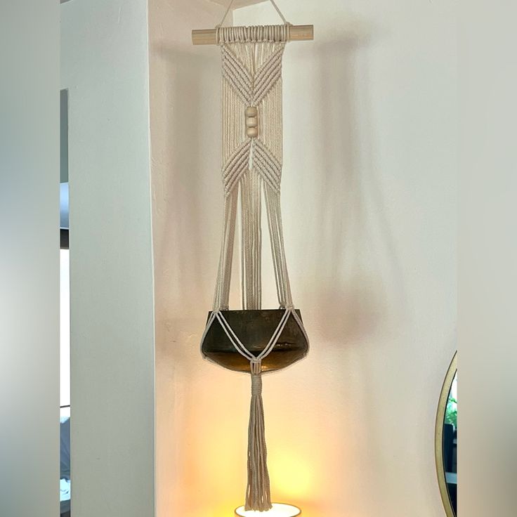 a lamp that is on top of a table next to a wall hanging with beads