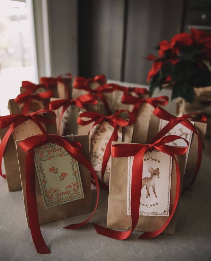 small gift bags with red ribbon tied around them