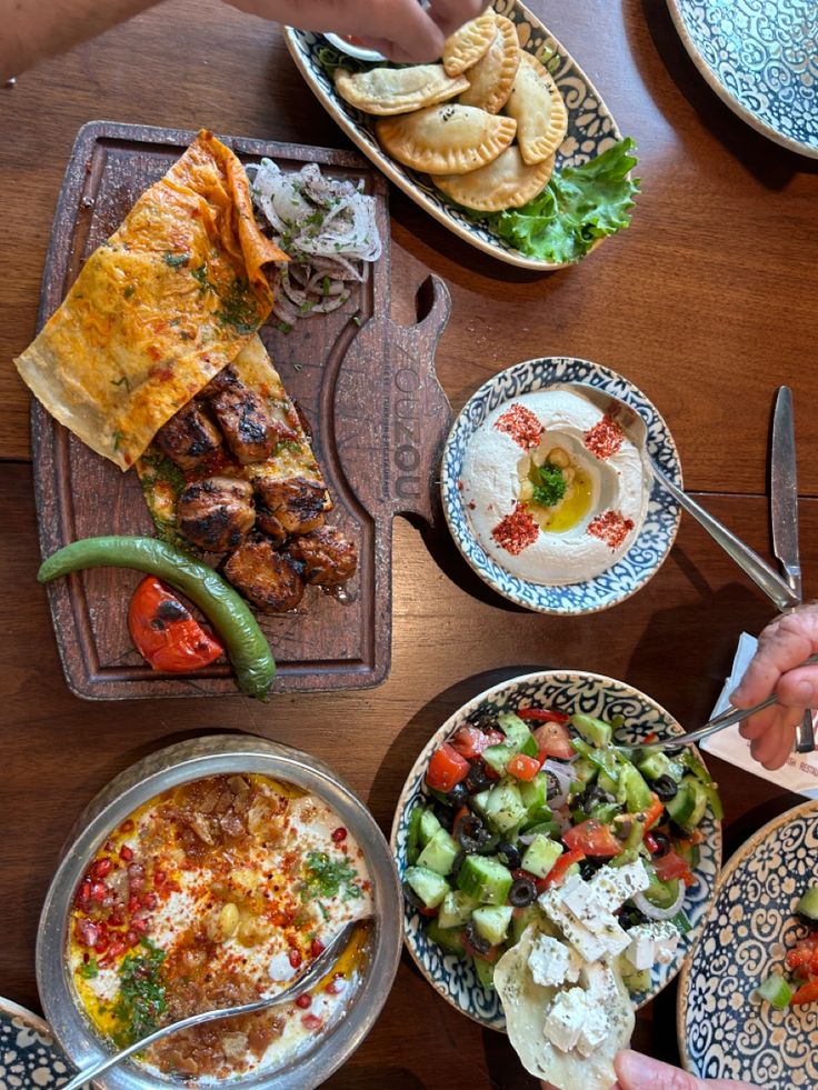 several plates of food on a wooden table